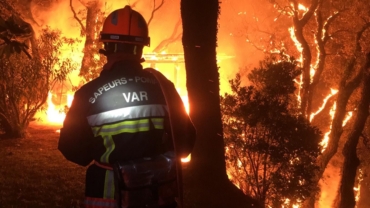 a fireman battles with a fire near Toulon early Tuesday,