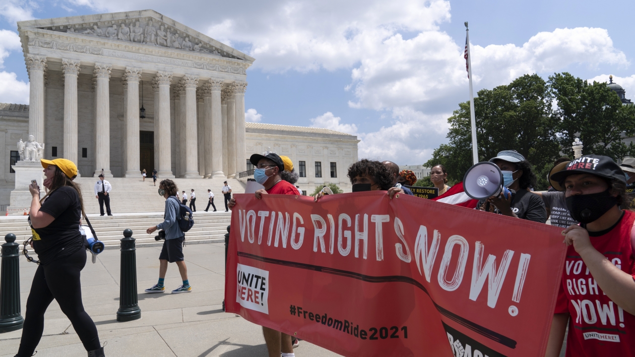 Voting rights activists march outside of the U.S. Supreme Court