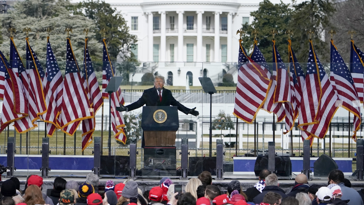 President Donald Trump speaks at a rally in Washington with the White House in the background.