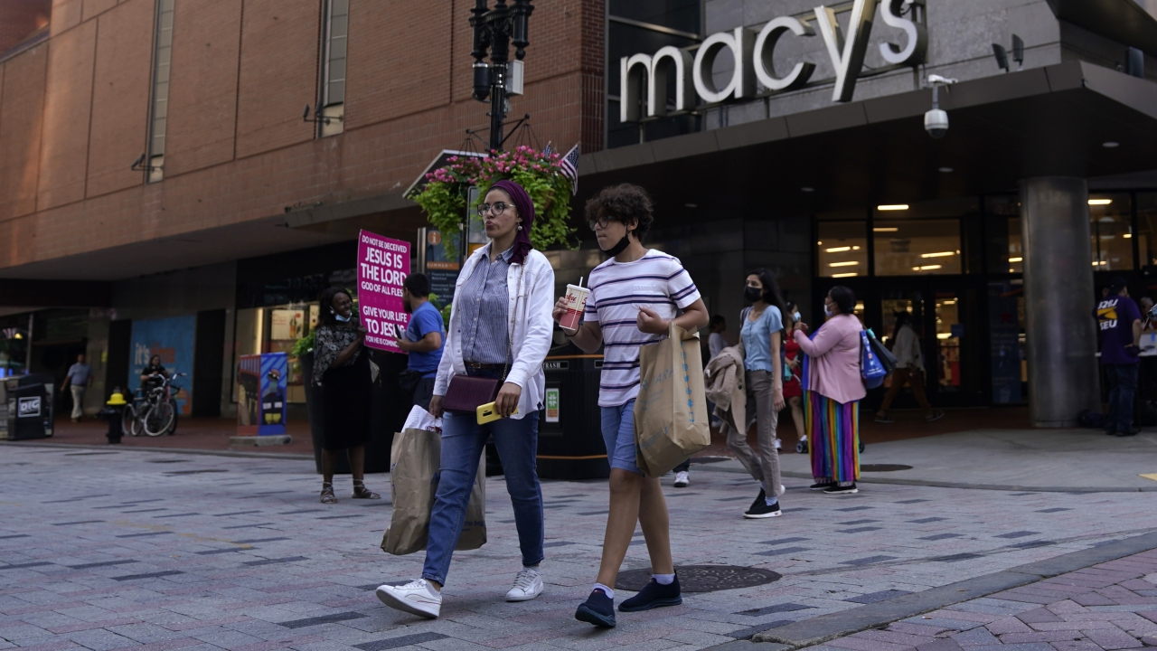 Pedestrians pass a Macy's store.