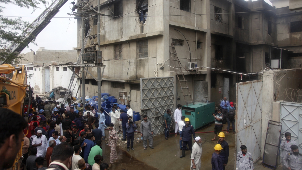 Rescue workers search bodies at the site of a burnt chemical factory, in Karachi, Pakistan