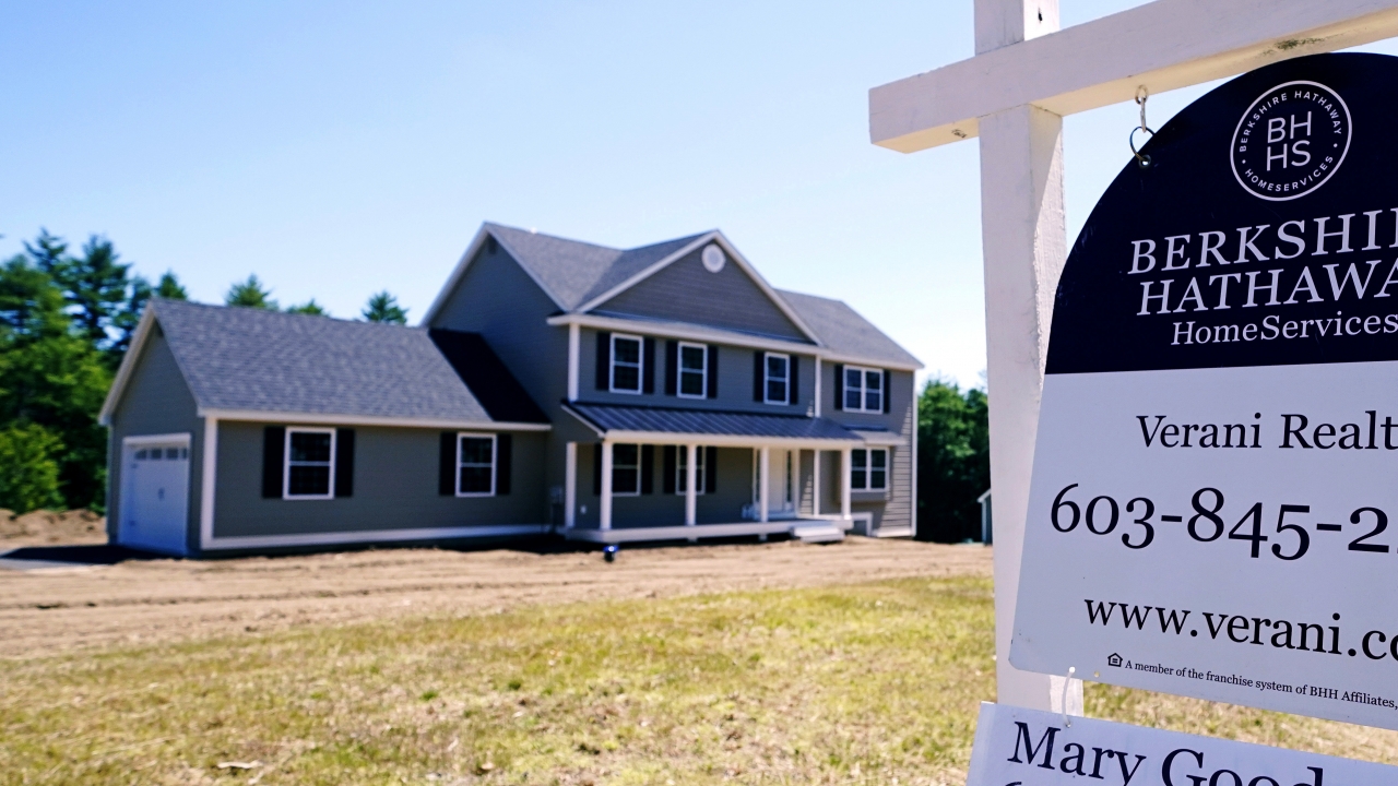 A real estate sign is posted in front of a newly constructed single family home.