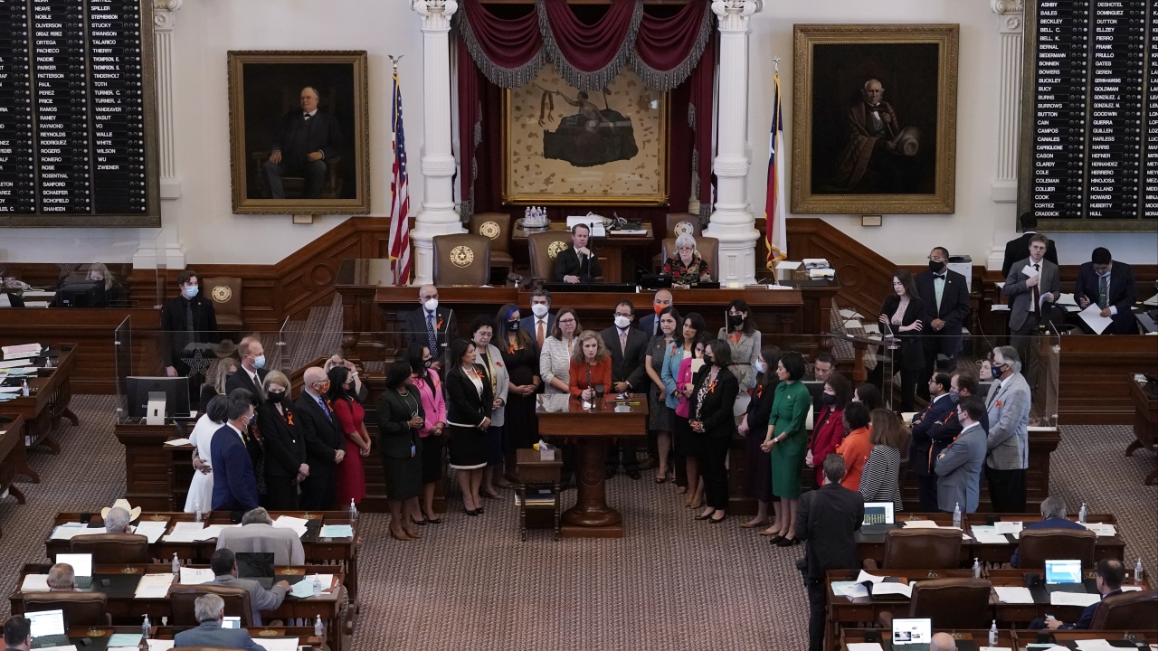 Texas state Rep. Donna Howard, D-Austin, center at lectern, stands with fellow lawmakers in the House Chamber in Austin, TX