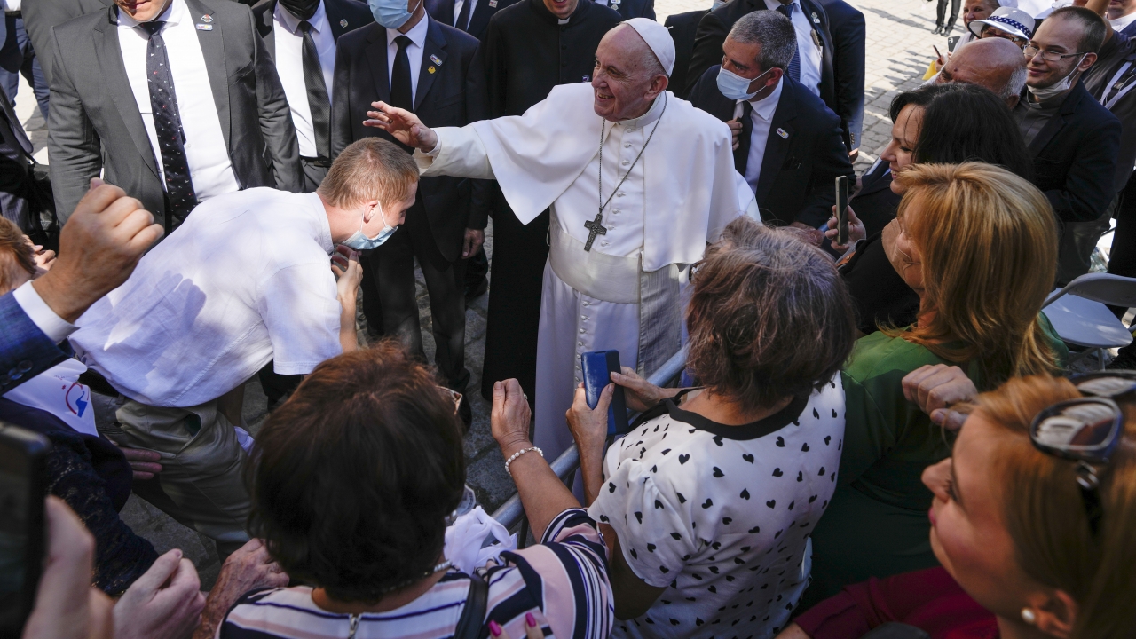 Pope Francis blesses an unidentified man as he greets the crowd while leaving the Cathedral of Saint Martin,