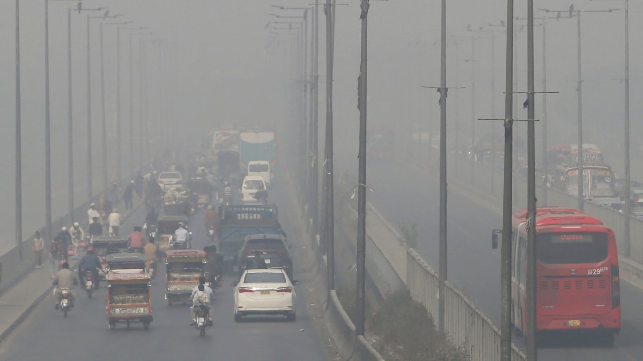 vehicles drive on a highway as smog envelops the area of Lahore, Pakistan