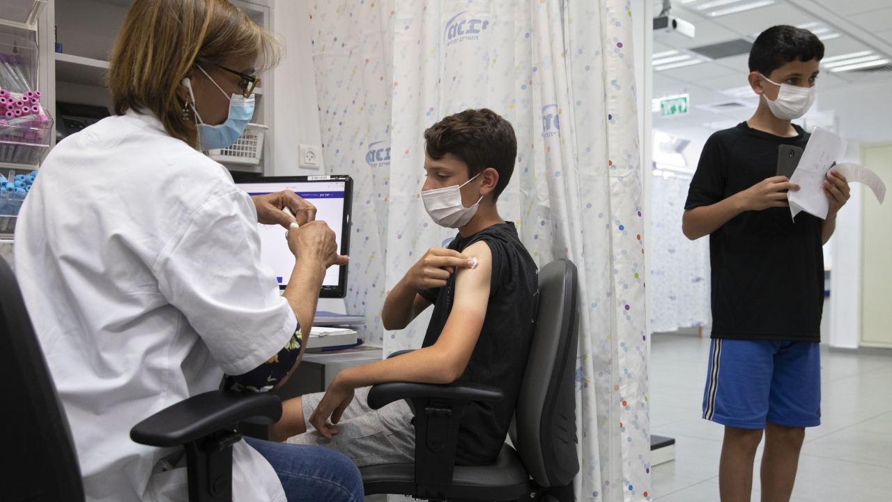 In this June 6, 2021 file photo, a youth receives a Pfizer-BioNTech COVID-19 vaccine in Israel.