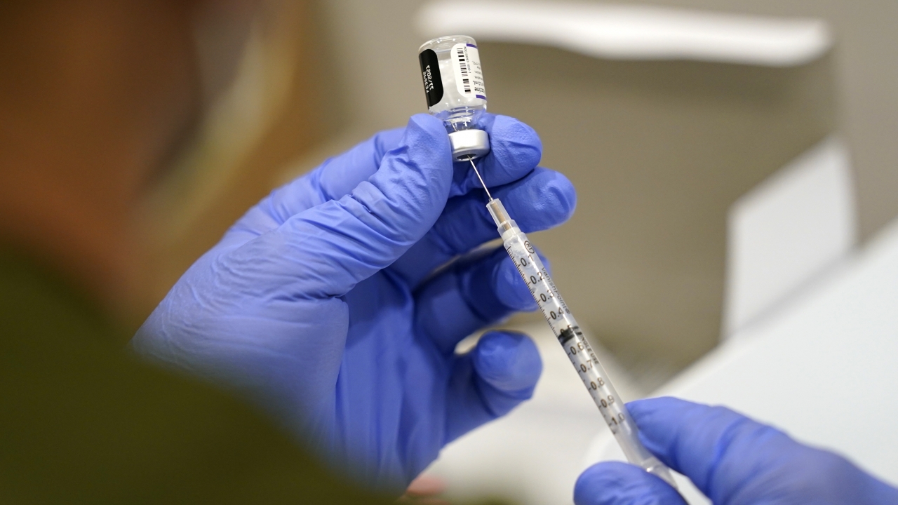 A healthcare worker fills a syringe with the Pfizer COVID-19 vaccine.