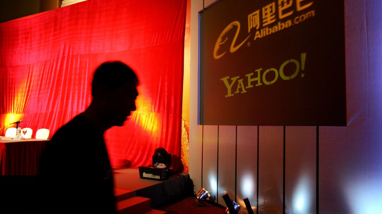 A man walks past a screen displaying the Yahoo logo
