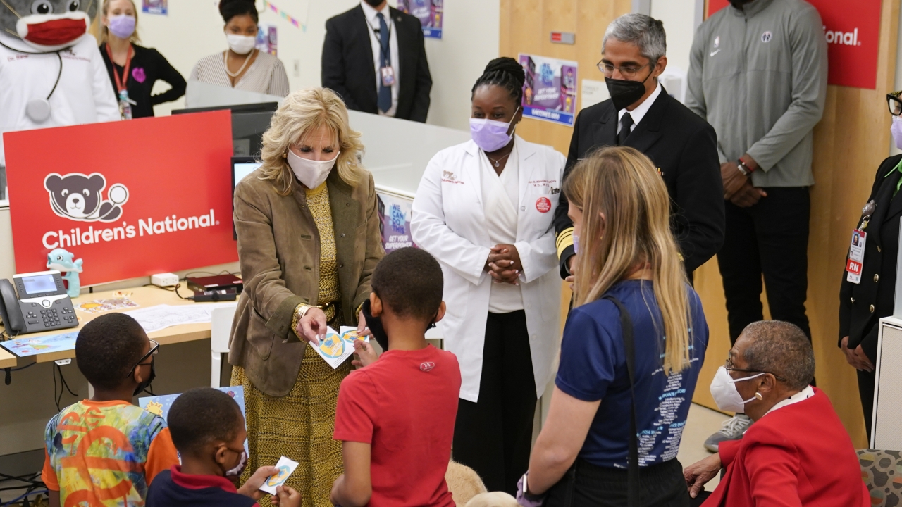 A photo of First Lady Jill Biden handing out stickers to children who were recently vaccinated against COVID.
