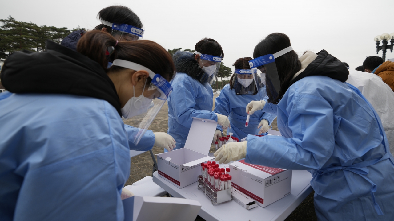 Medical workers wearing protective gear prepare to take samples at a temporary screening clinic for coronavirus in Seoul