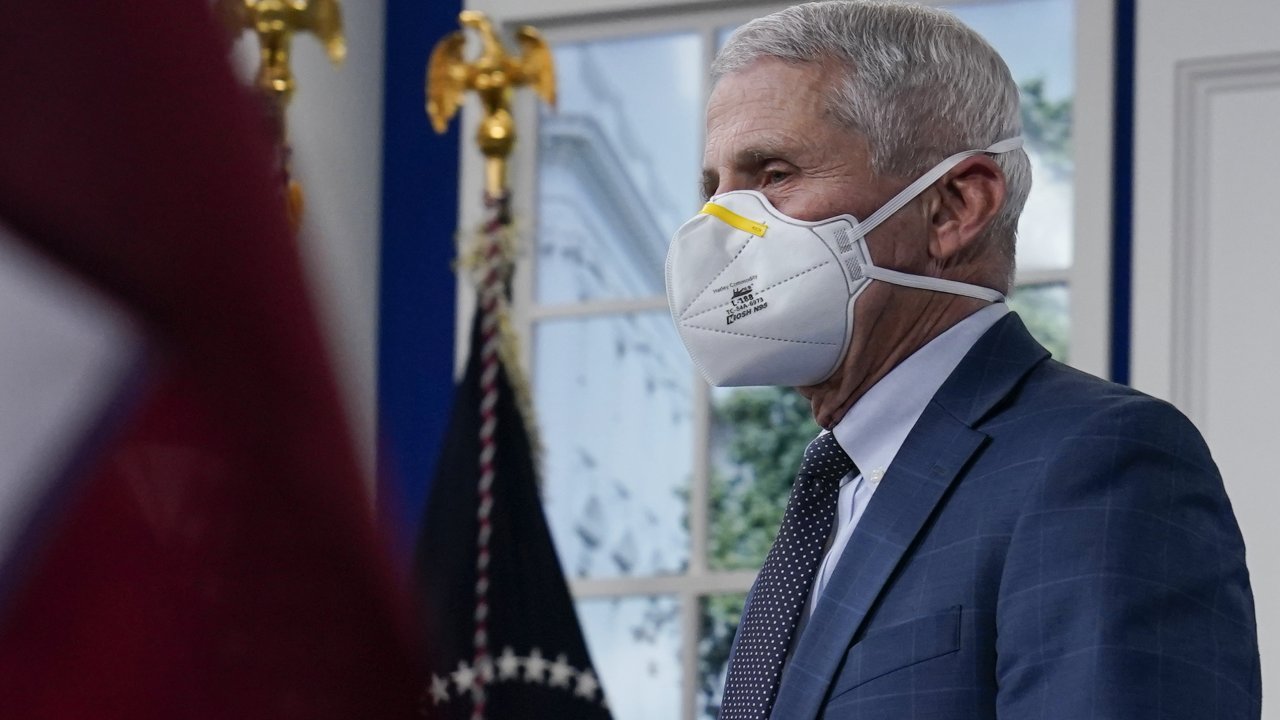Dr. Fauci stands with a mask on.