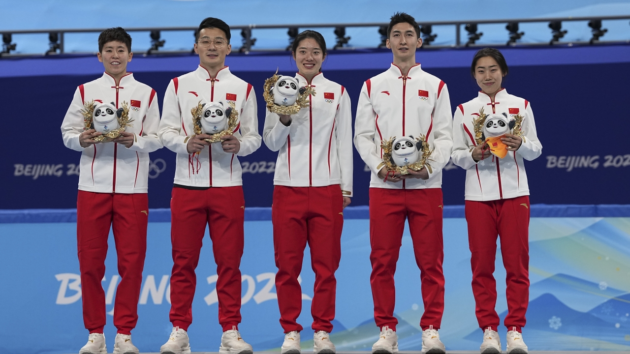 Team China celebrate on the podium after winning the gold medal in the mixed team relay.