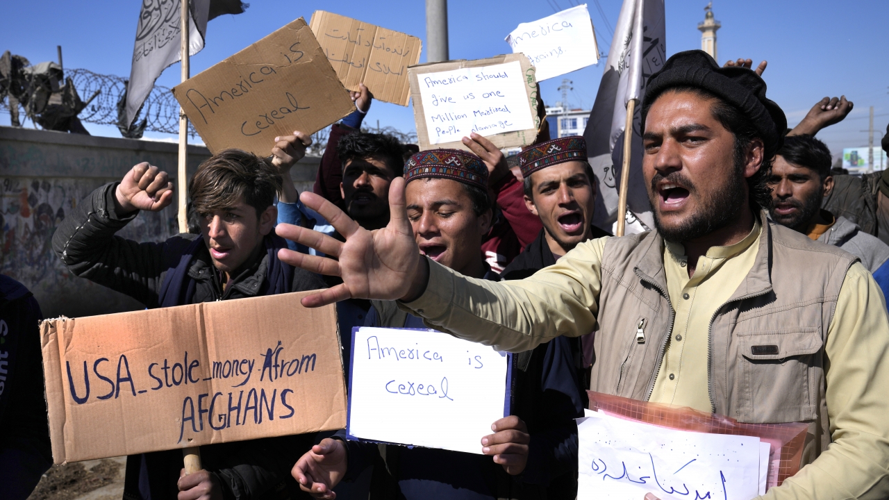 Afghan protesters hold placards and shout slogans against U.S.