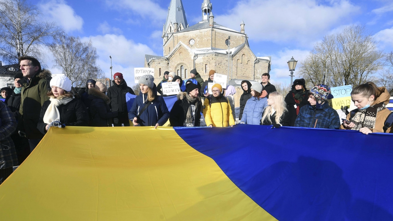 People hold a huge Ukrainian national flag during a protest in support of Ukraine