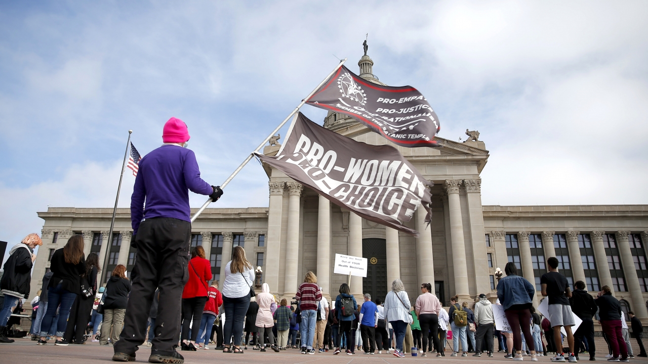 A person holds pro-choice flags during the Bans Off Oklahoma Rally on the steps on Oklahoma state Capitol