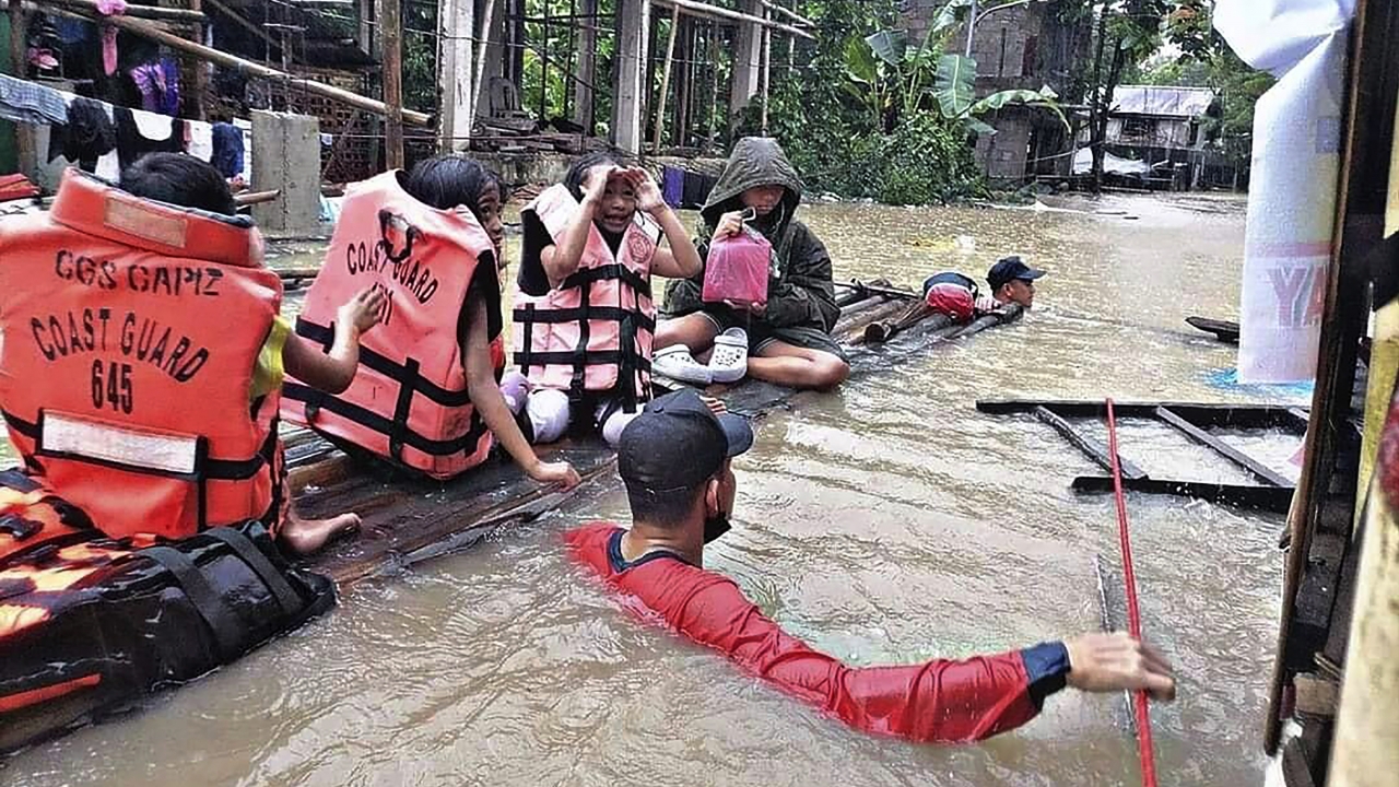 People on a raft being evacuated from floods and landslides in Philippines