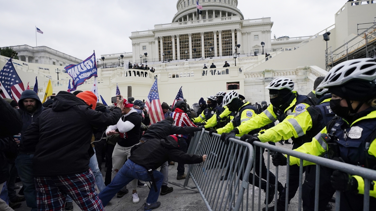 Insurrectionists loyal to President Donald Trump try to break through a police barrier at the Capitol on January 6, 2021