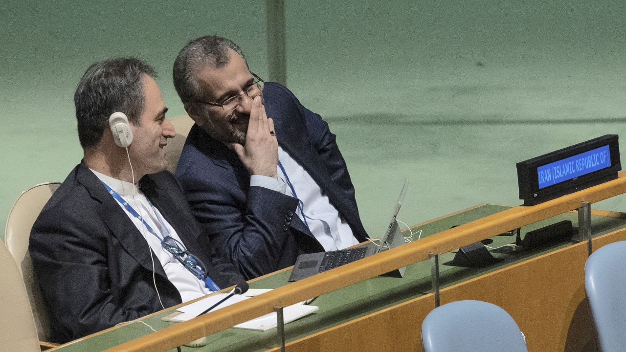 Iran's delegates chat with each other at a meeting