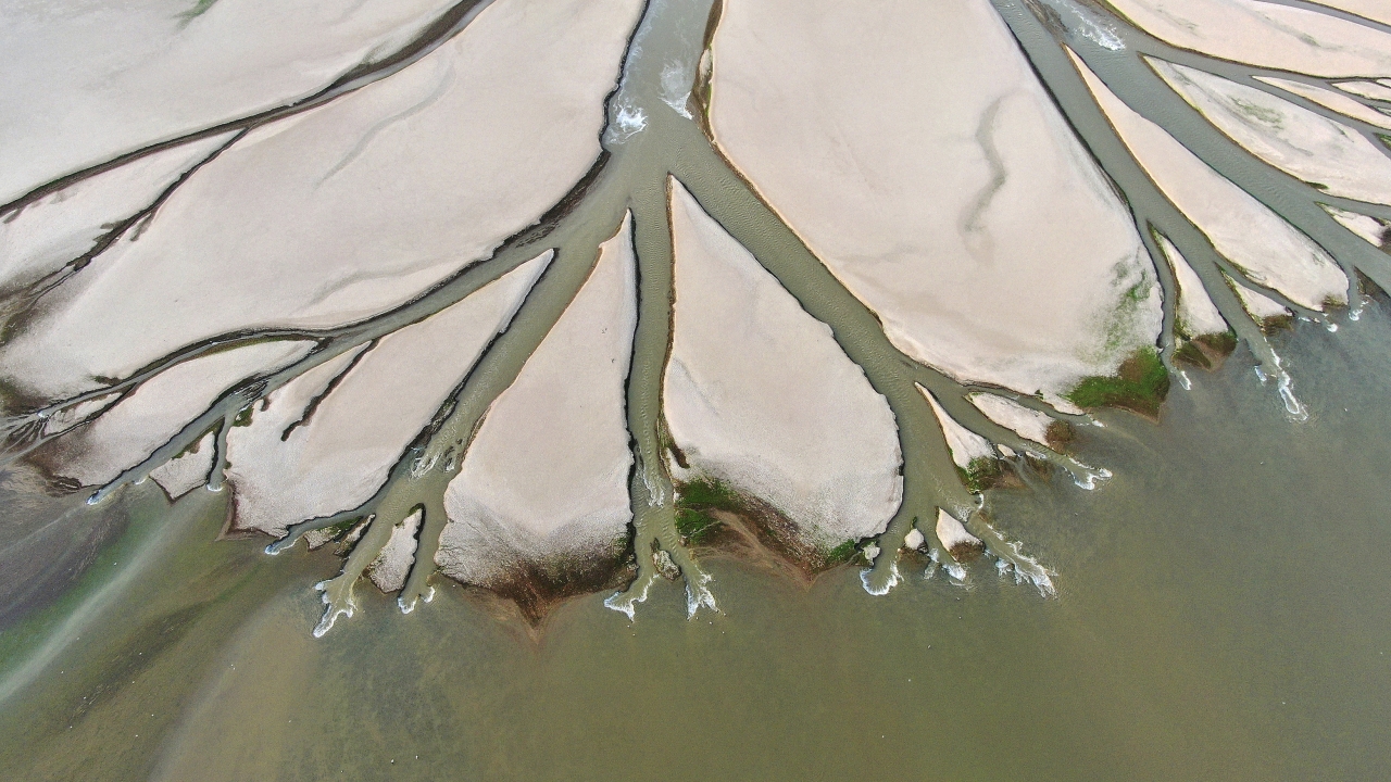 In this aerial photo released by China's Xinhua News Agency, water flows through chanels in the lake bed of Poyang Lake