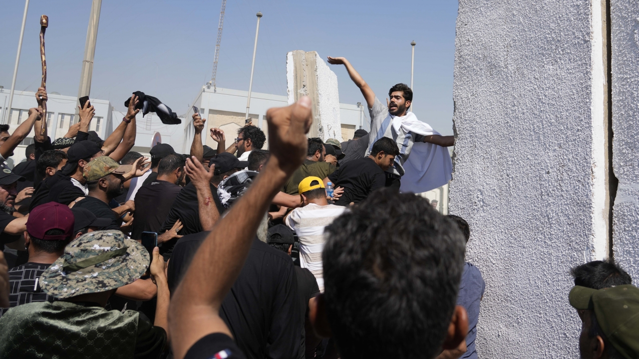 Supporters of Shiite cleric Muqtada al-Sadr try to remove concrete barriers