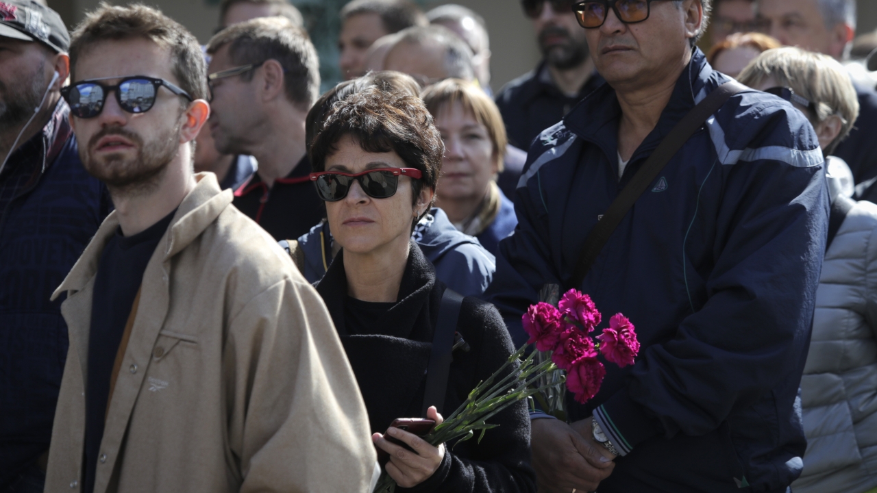 A woman holding flowers look on as she lines up to pay respects to former Soviet President Mikhail Gorbachev.