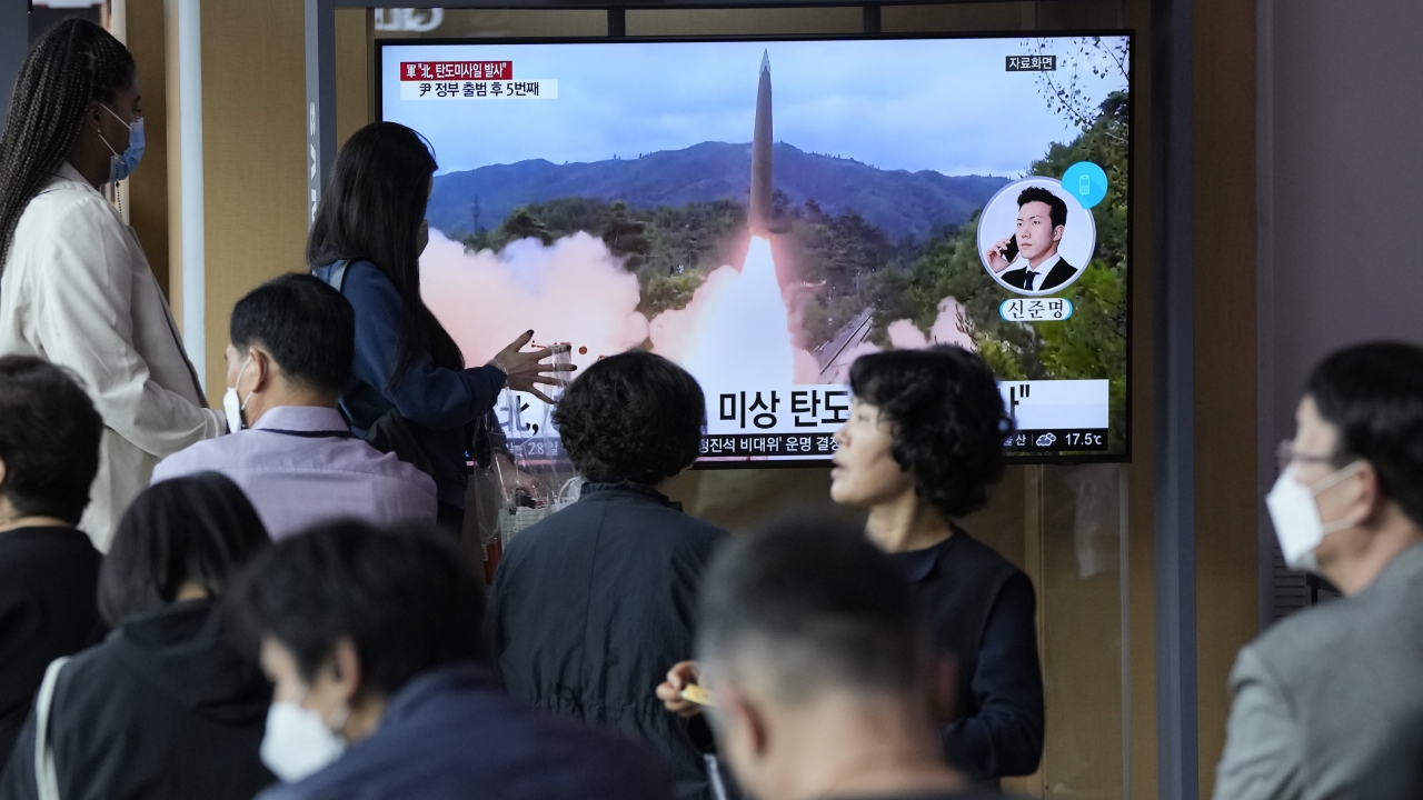 People watch a news program showing a file image of a missile launch by North Korea