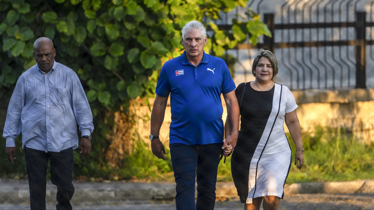 Cuba's President Miguel Diaz Canel walks with his wife Lis Cuesta Peraza before casting his vote.