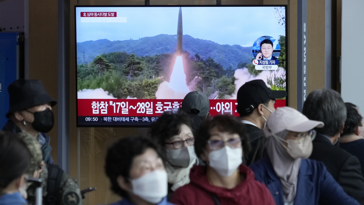 Tv screen shows a North Korean rocket launch.