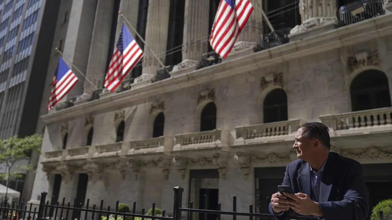 A trader stands outside the New York Stock Exchange