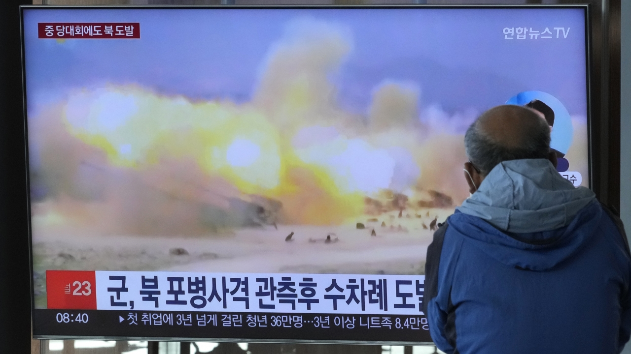 TV screen shows North Korean missile launch.