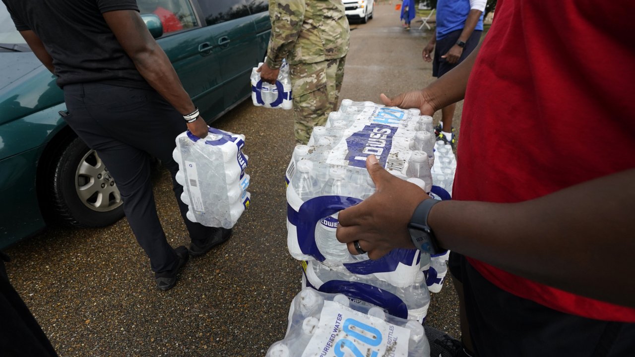 Volunteers distribute cases of water at a community/fraternal drive-thru water distribution site in Jackson, Mississippi