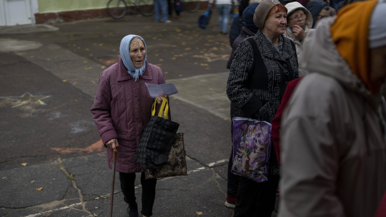 People queue to receive a daily ration of bread in a school in Mykolaiv, Ukraine