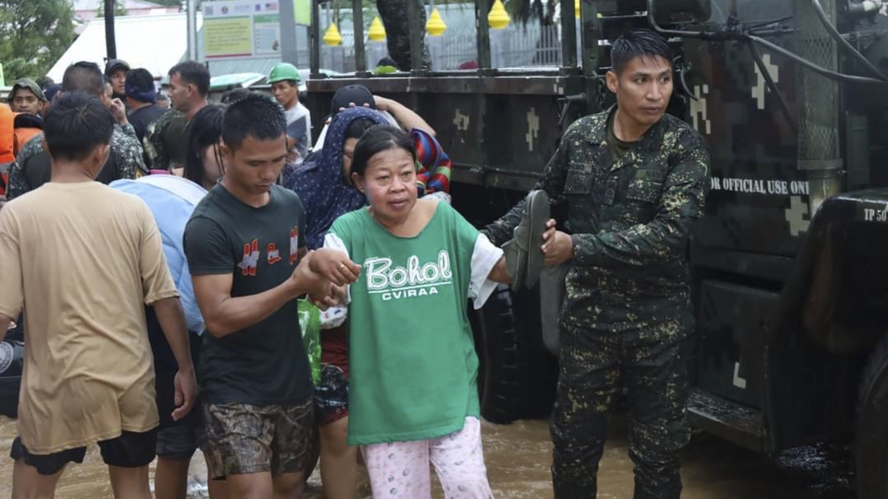 Rescuers help woman from flood waters.