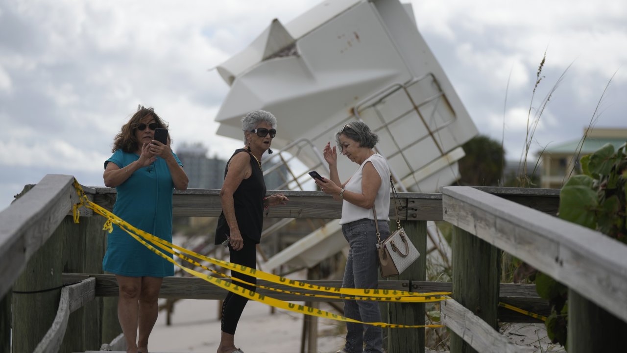 People inspect damage from then-Hurricane Nicole