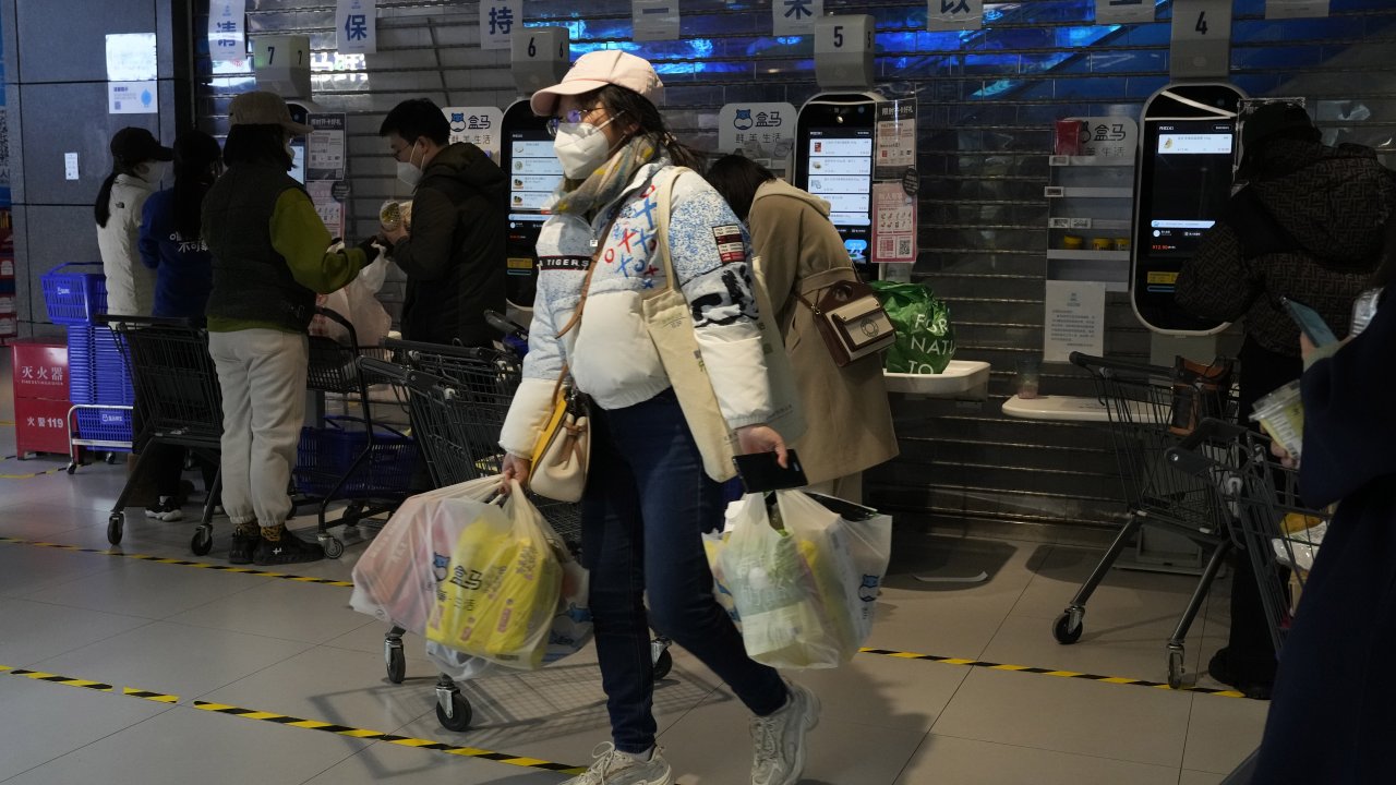 A shopper carries groceries at a supermarket