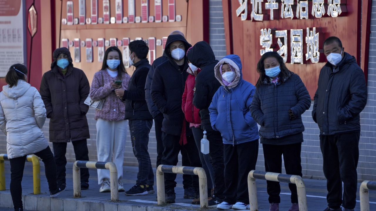 Residents wearing face masks line up for their routine COVID-19 tests