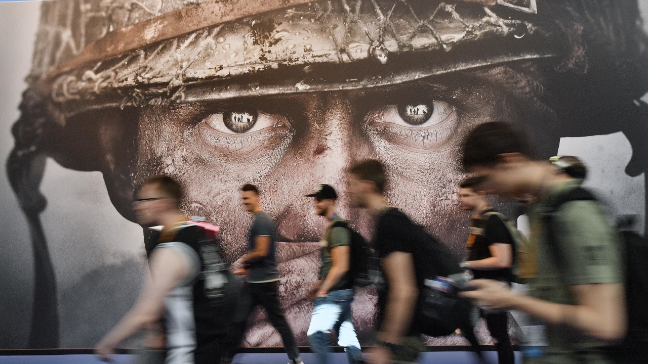 Visitors passing an advertisement for the video game 'Call of Duty.'