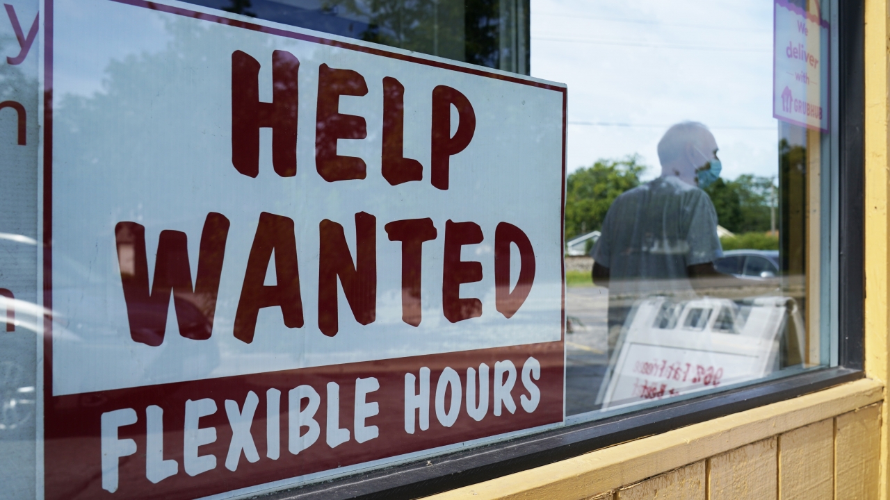 A "help wanted" sign displayed in a business window.