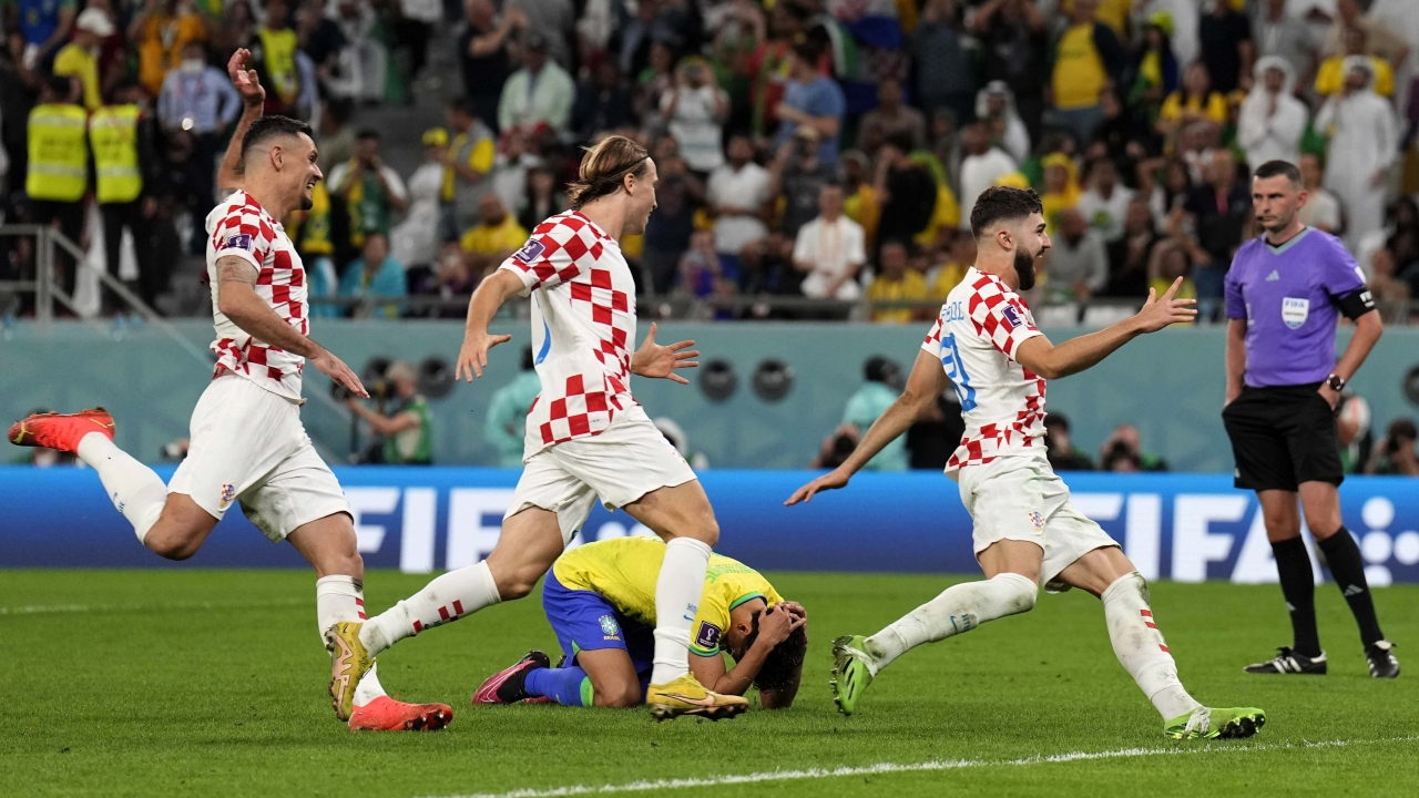 Brazil's Marquinhos lies on the ground as Croatia's player celebrate.
