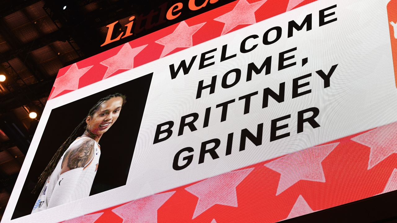 A monitor at a basketball game reads, "Welcome Home Brittney Griner," alongside a photo of the WNBA player.