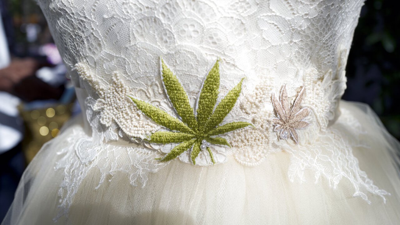 A wedding dress with an embroidered marijuana leaf on the front.