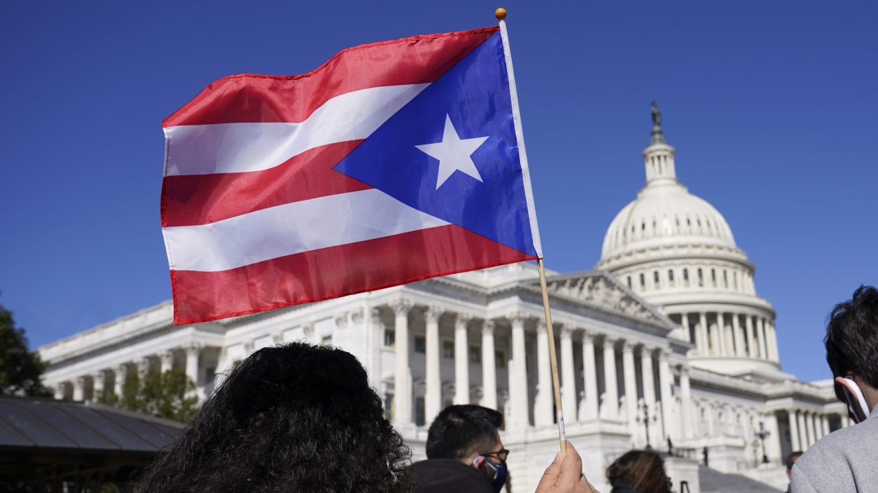 A person waves the flag of Puerto Rico during a news conference on Puerto Rican statehood on Capitol Hill.