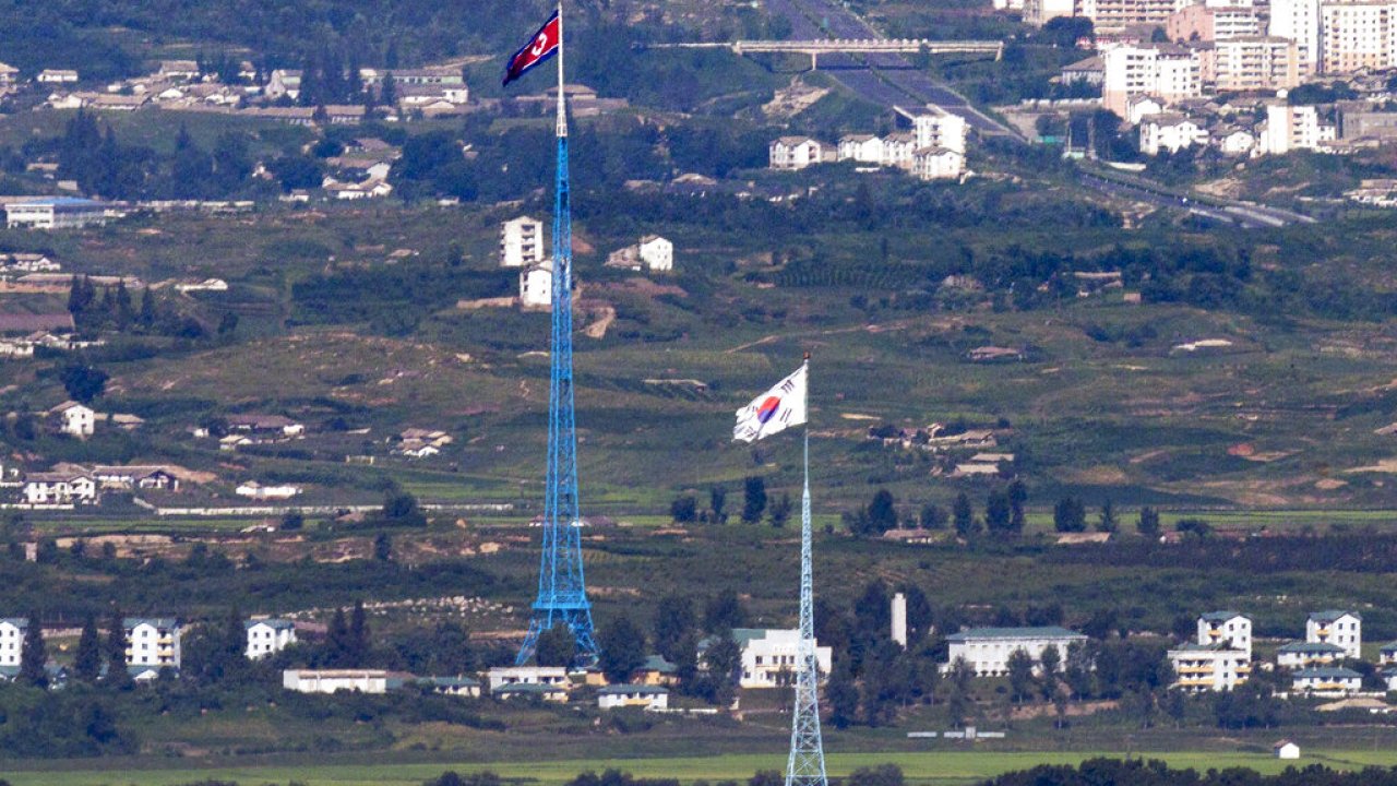 Flags of North Korea and South Korea flutter in the wind at the border area between the two countries.