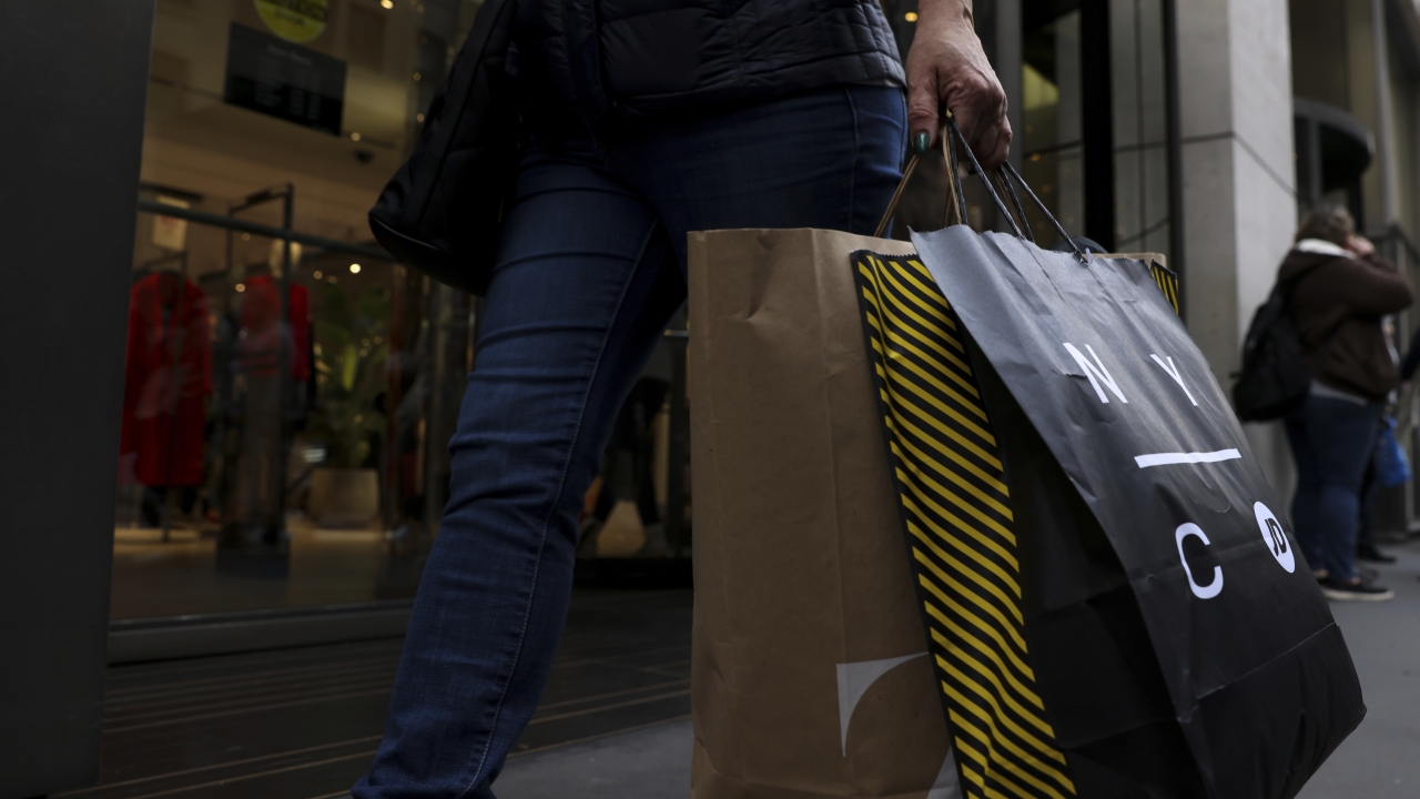 A shopper carries bags down Fifth Avenue.