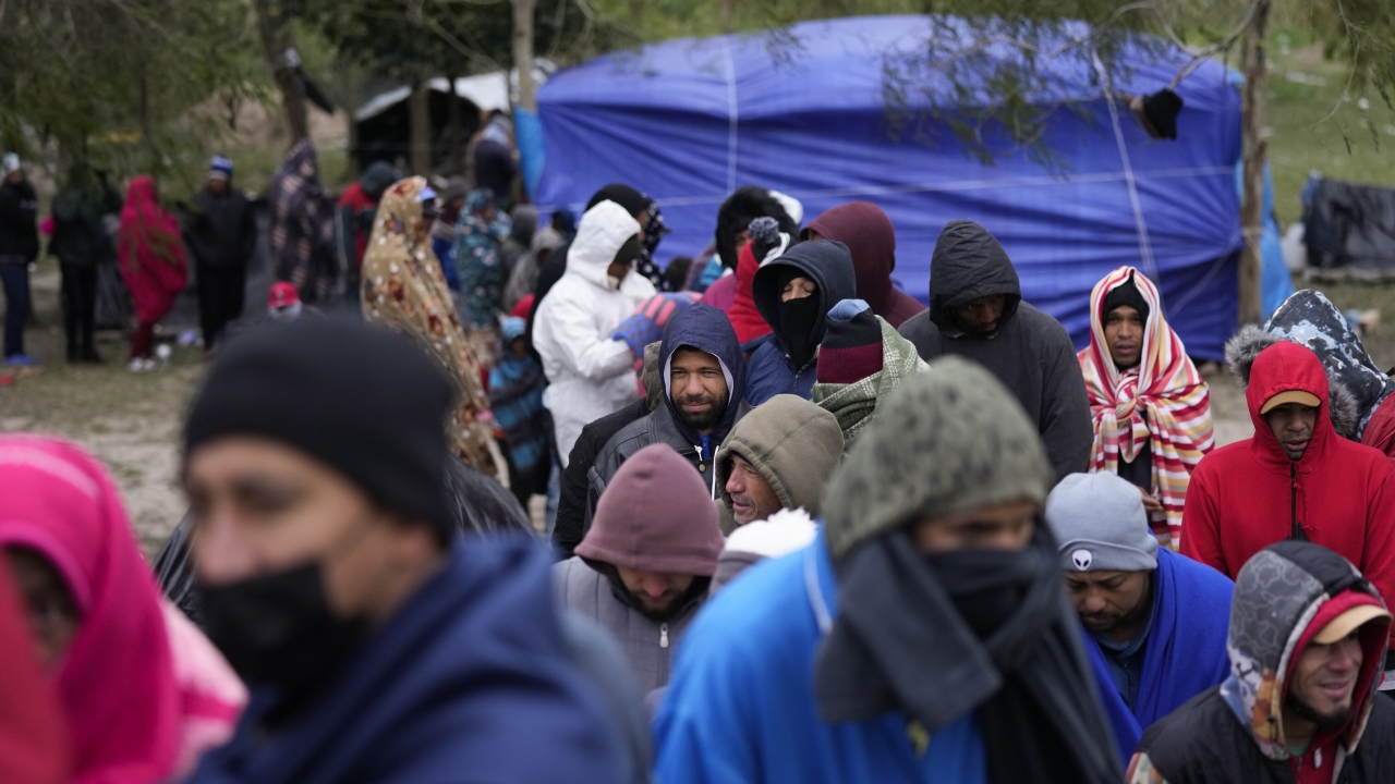 Migrants from Venezuela line up in the cold weather for hot drinks and food from volunteers at a makeshift camp