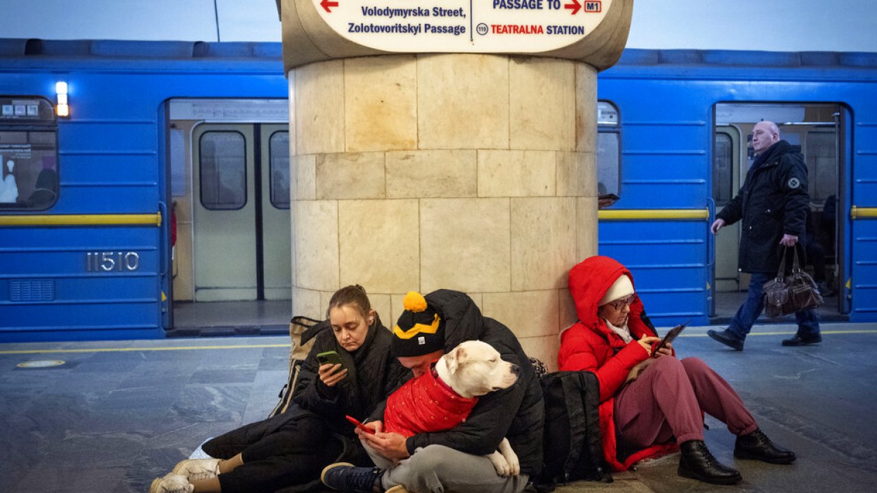 People sit in the subway station being used as a bomb shelter during a rocket attack in Kyiv, Ukraine.
