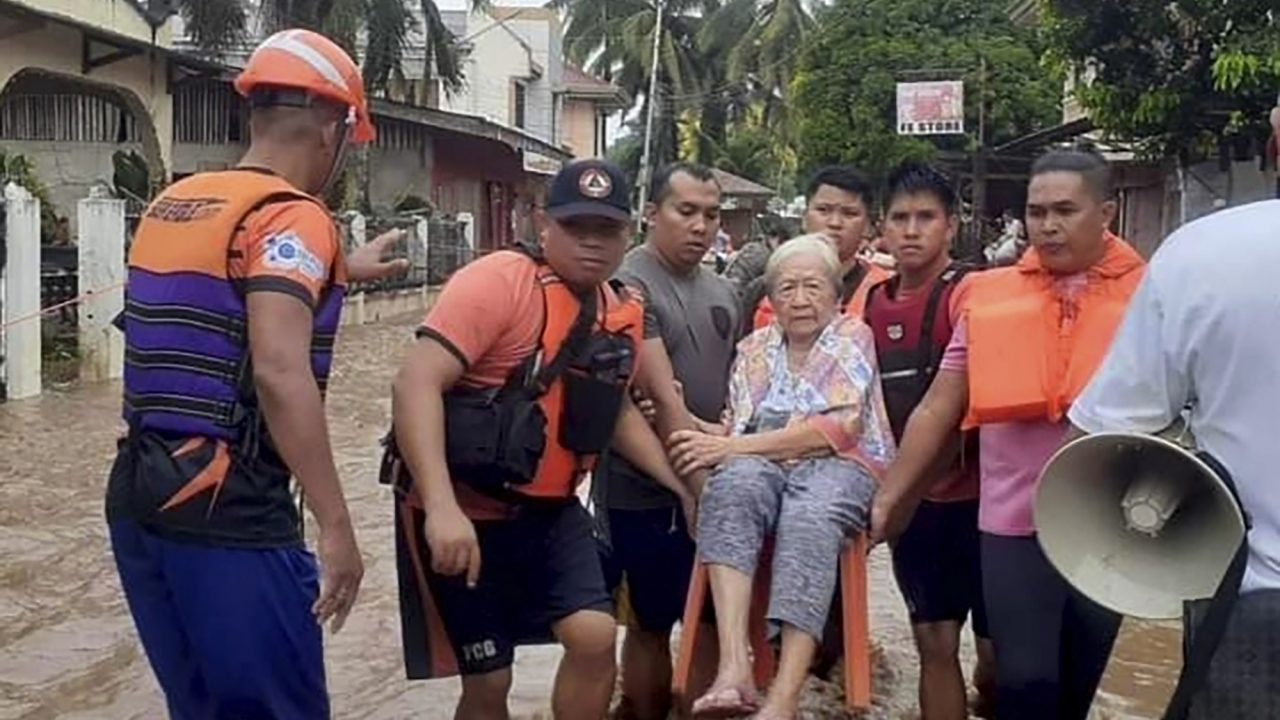 Philippine Coast Guard rescue a woman from floods.