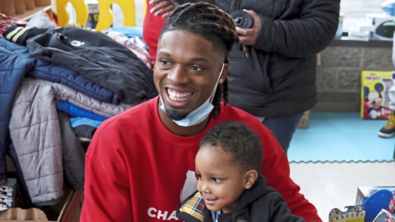 Damar Hamlin poses with a child who picked out a toy from Hamlin's toy drive for kids.