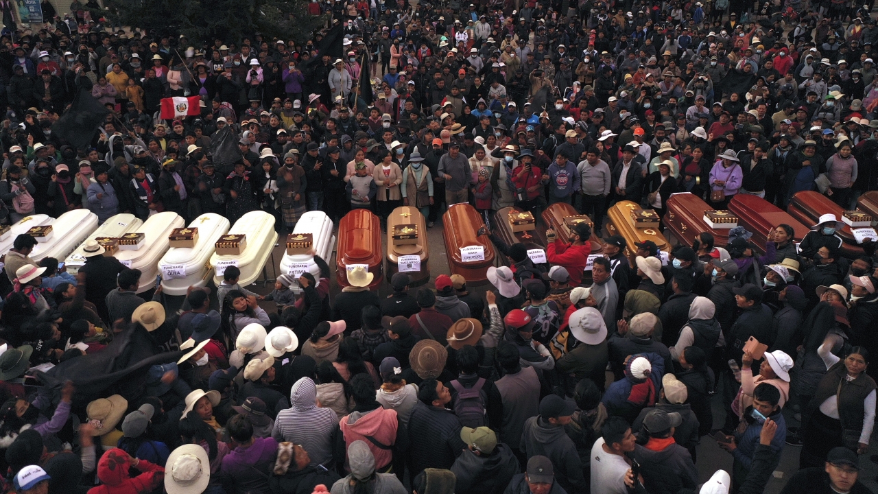 Peruvians surround coffins during a vigil.