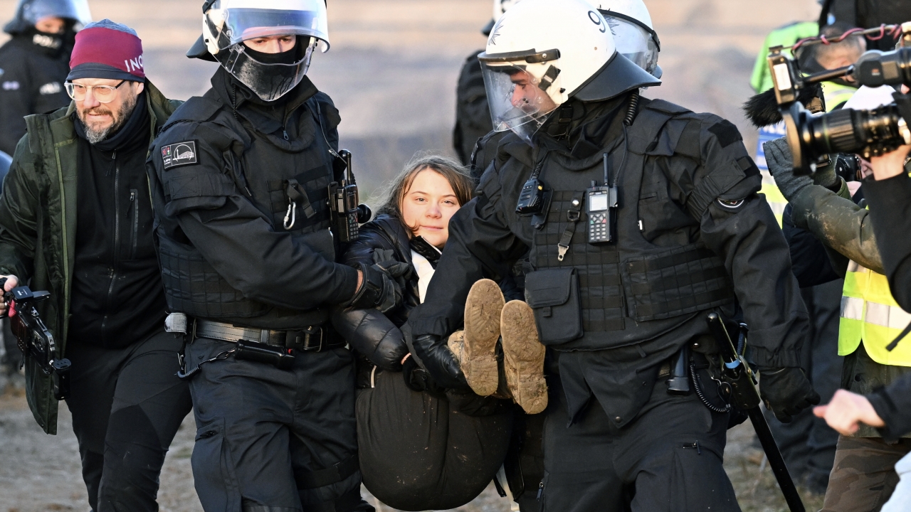 Police officers carry Swedish activist Greta Thunberg away.